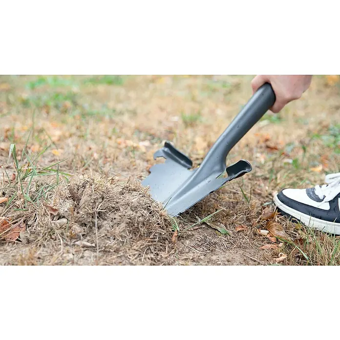 BAUHAUS Rodespaten - Arbeitsbreite: 34,5 cm, Länge: 114 cm - Nahaufnahme eines Spatens, der in Erde sticht, was die robuste Konstruktion und den Einsatz des Werkzeugs hervorhebt.