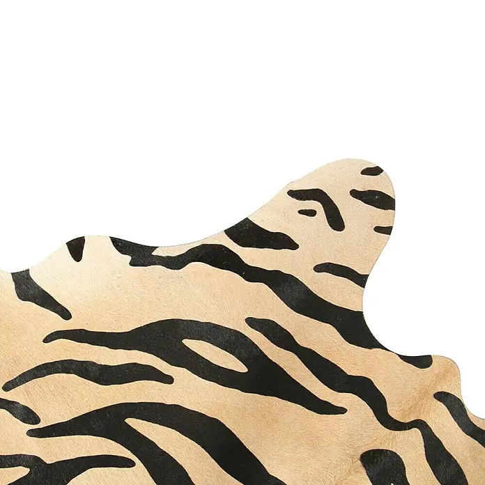 Esbeco Kuhfell - 100 % Echtfell, Tiger - Detailaufnahme einer Teppichdecke in Tierfelloptik mit auffälligen schwarzen Streifen auf beigem Grund. Ein modischer Hingucker für jeden Raum.