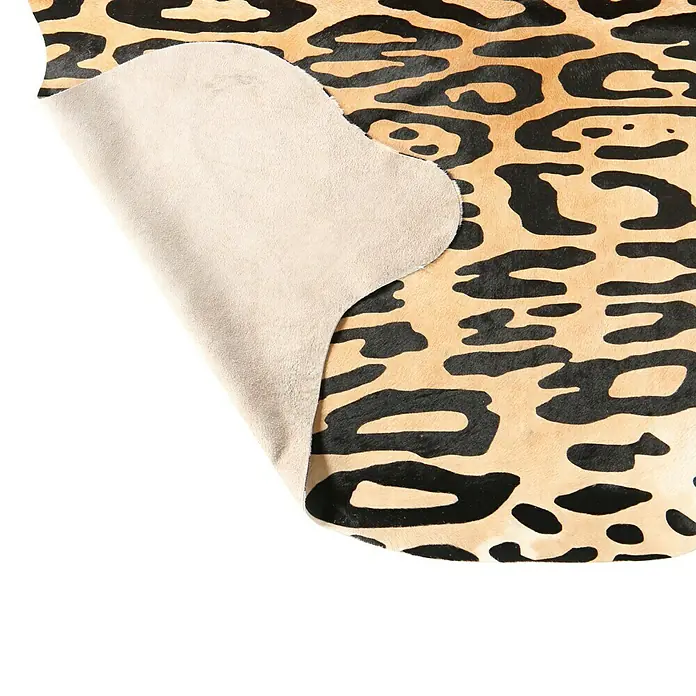 Esbeco Kuhfell - 100 % Echtfell, Jaguar - Nahaufnahme eines Tierfells mit auffälligem Leopardenmuster und hellbeiger Lederrückseite, das die Textur und das Design hervorhebt.