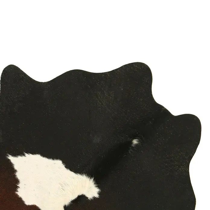 Esbeco Kuhfell - Exotisch Dunkel, 100 % Echtfell - Detailansicht einer Kuhfell-Teppichoberfläche mit einem Muster aus Schwarz, Weiß und Braun und unregelmäßigen Rändern.