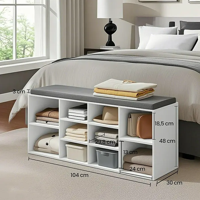 Schuhbank - 30 x 104 x 48 cm, Weiß/Grau - Das Bild zeigt eine weiße Schuhbank mit grauem Sitzkissen, die vor einem Bett steht und mit Maßen beschriftet ist.