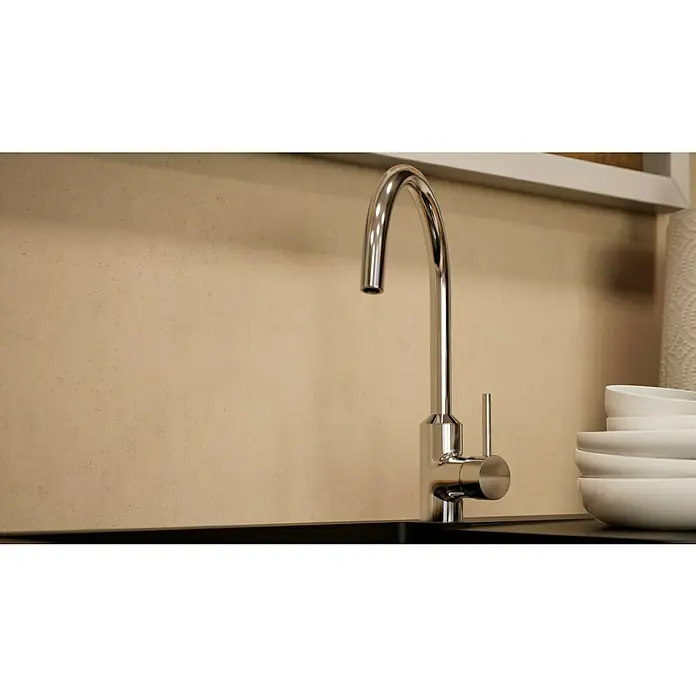 BAUHAUS Winkelküche Sandra - B x T: 310 x 170 cm, Grau, Matt, Farbe Korpus: Artisan Eiche, Mit Elektrogeräten - Nahaufnahme einer eleganten Spültischarmatur aus Chrom mit schlankem Design vor einer schlichten Wand. Geschirrstapel rechts.
