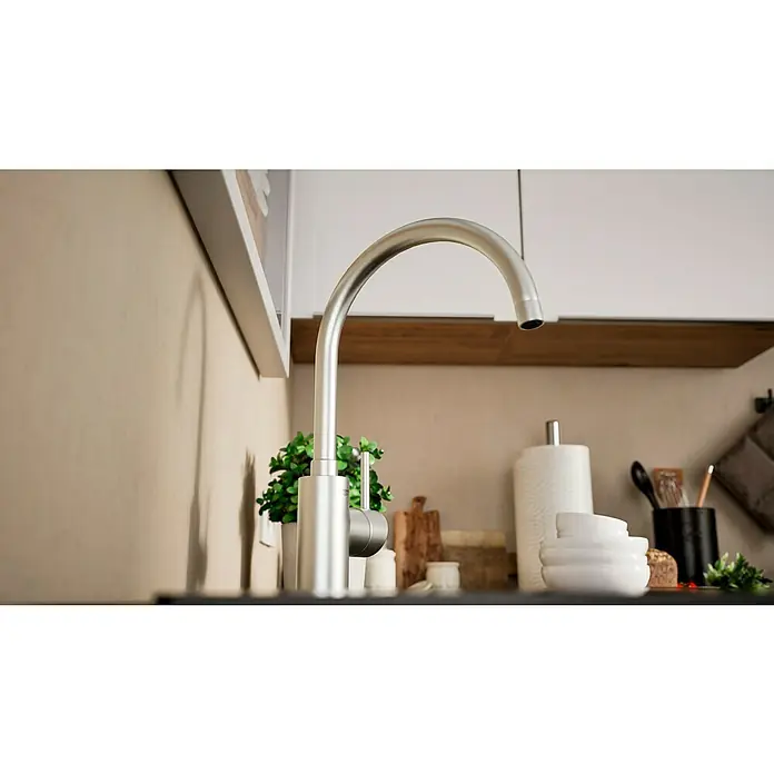 Grohe Concetto Spültischarmatur - Edelstahl, Schwenkbar - Nahaufnahme einer modernen Küchenarmatur aus gebürstetem Stahl mit minimalistischem Design vor Küchenutensilien und Dekoration.