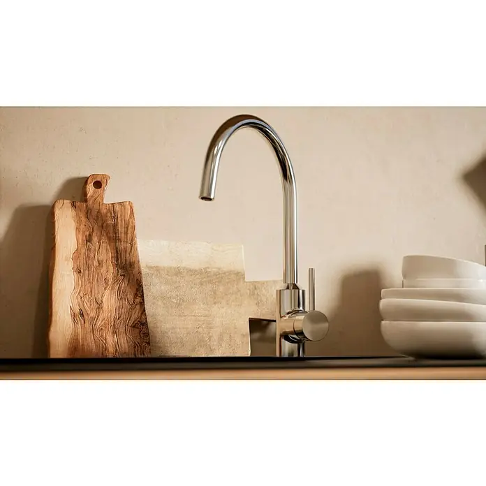 BAUHAUS Küchenzeile Sandra - Breite: 280 cm, Grau, Farbe Korpus: Artisan Eiche, Mit Elektrogeräten - Eine moderne Küchenarmatur aus Chrom steht im Fokus, begleitet von einem Holzbrett und weißen Schüsseln vor einem sanften Hintergrund.