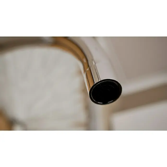 Grohe Concetto Spültischarmatur - Chrom, Glänzend, Wandmontage - Nahaufnahme eines glänzenden, verchromten oder Edelstahlrohrs mit dunkler Öffnung vor hellem Hintergrund.