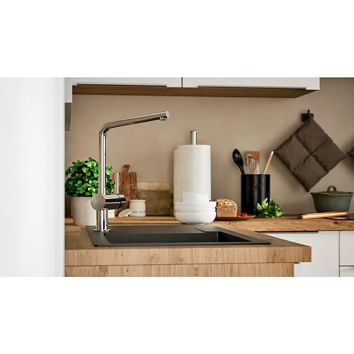 Grohe Spültischarmatur Minta - L-Auslauf, Chrom, Glänzend, Schwenkbar - Küchenspüle mit Armatur und Küchenutensilien. Die Armatur ist aus Chrom und die Spüle aus schwarzem Material mit Holzplatte.