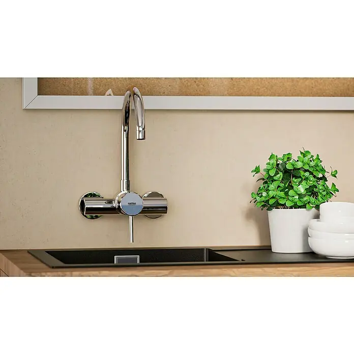 Grohe Concetto Spültischarmatur - Chrom, Glänzend, Wandmontage - Ein moderner Grohe Wasserhahn über einer schwarzen Spüle mit Pflanze und weißen Schüsseln im Hintergrund.