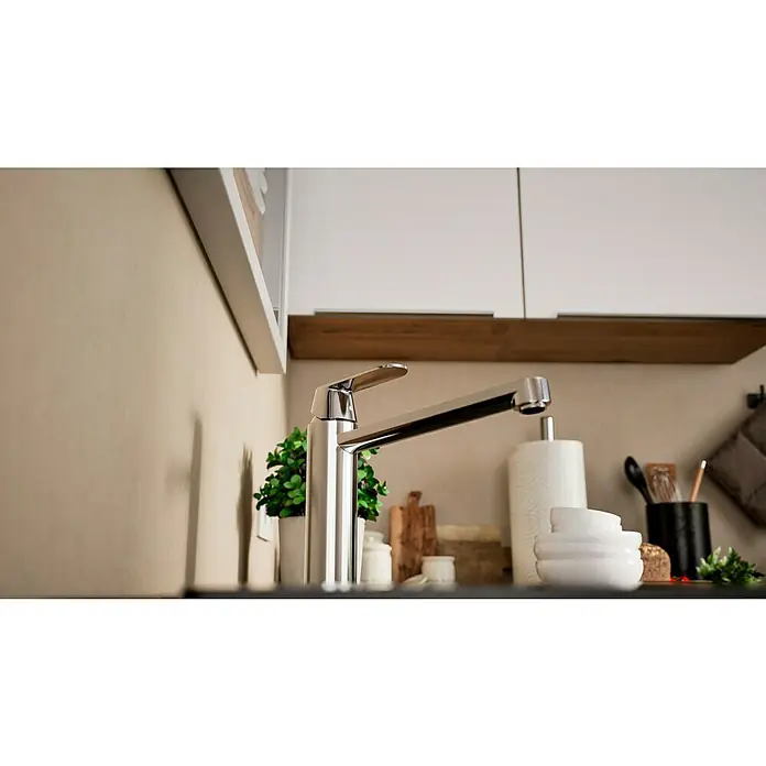 Grohe Eurosmart Cosmopolitan Spültischarmatur - L-Auslauf, Chrom, Glänzend, Schwenkbar - Nahaufnahme eines modernen, glänzenden Wasserhahns in einer stilvollen Küche. Der Fokus liegt auf dem eleganten Design des Wasserhahns.