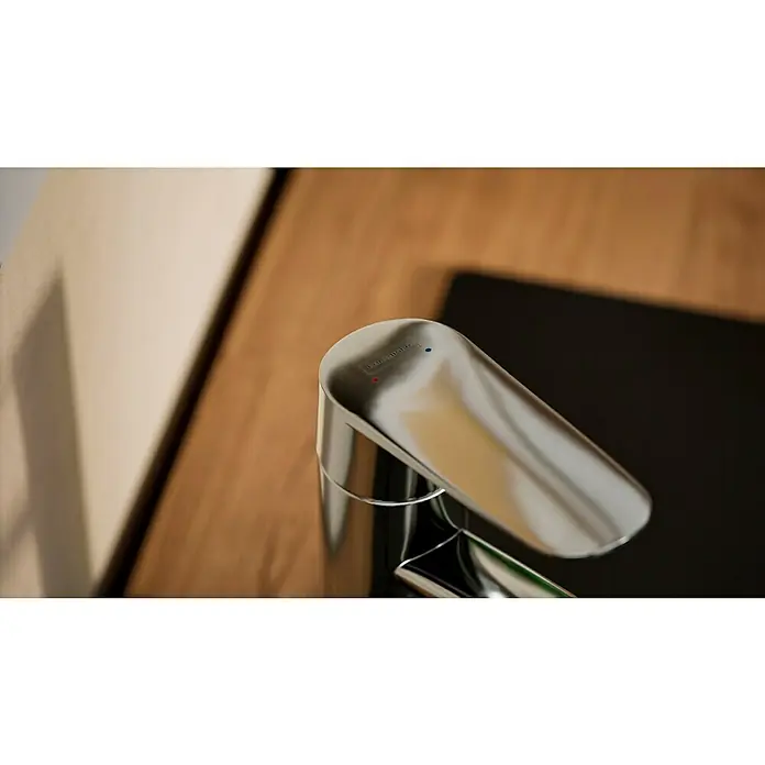 Hansgrohe Grifo de cocina - Cromo, Brillante - Primer plano de un grifo cromado moderno con indicadores de temperatura rojos y azules, situado sobre una encimera de madera.