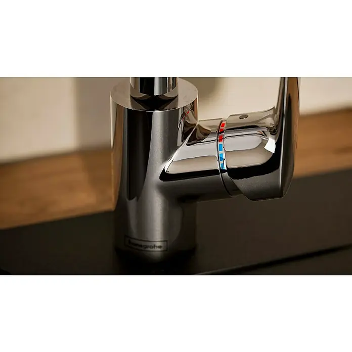 Hansgrohe Grifo de cocina Logis 260 - Cromo, Brillante - Primer plano de un grifo Hansgrohe cromado brillante con indicadores de temperatura, montado sobre una superficie oscura. Diseño elegante.