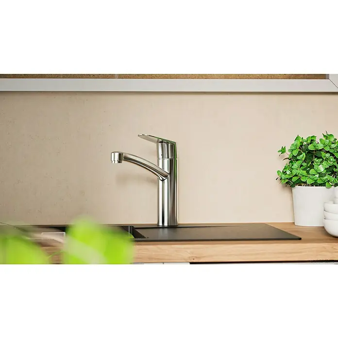 Hansgrohe Grifo de cocina - Cromo, Brillante - Grifo de cocina de acero inoxidable en una encimera junto a una olla verde de albahaca. Diseño contemporáneo para cocinas modernas.