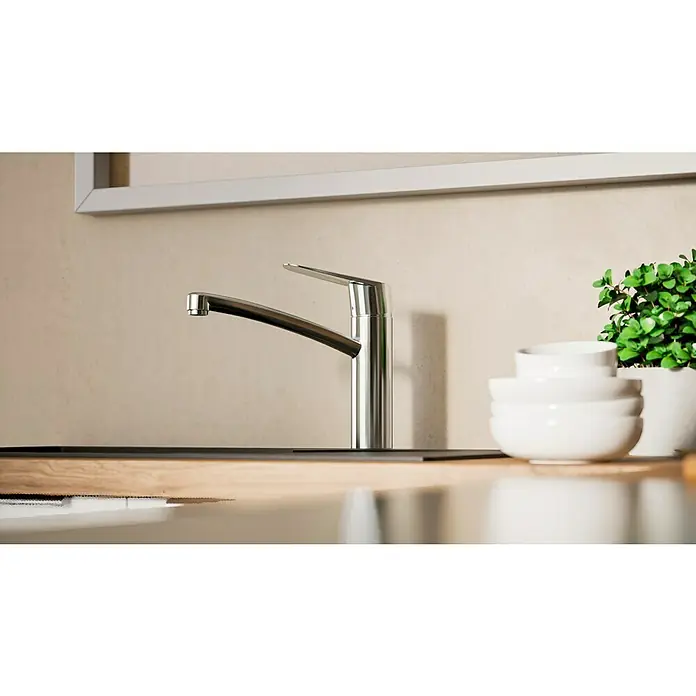 Hansgrohe Grifo de cocina - Cromo, Brillante - Primer plano de un moderno grifo de cocina de acero inoxidable, complementado con cuencos blancos y una planta en maceta.