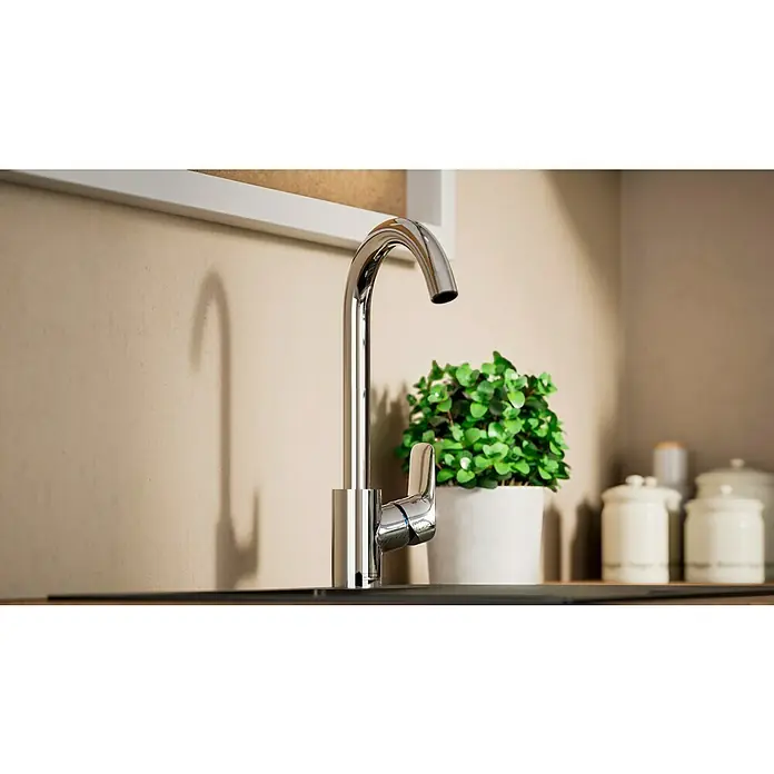 Hansgrohe Grifo de cocina Logis 260 - Cromo, Brillante - Un grifo cromado moderno y brillante que combina funcionalidad y estilo en una cocina, con una planta y recipientes al fondo.