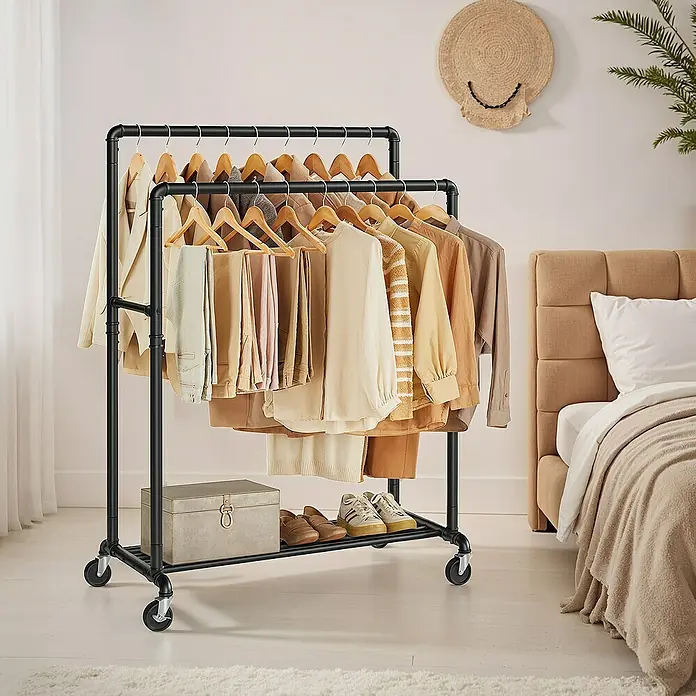 Kleiderwagen - L x B x H: 59 x 100 x 162 cm, Schwarz - Eine zweistöckige, schwarze Kleiderstange auf Rollen, voll mit beige- und cremefarbener Kleidung, steht in einem hellen Schlafzimmer.
