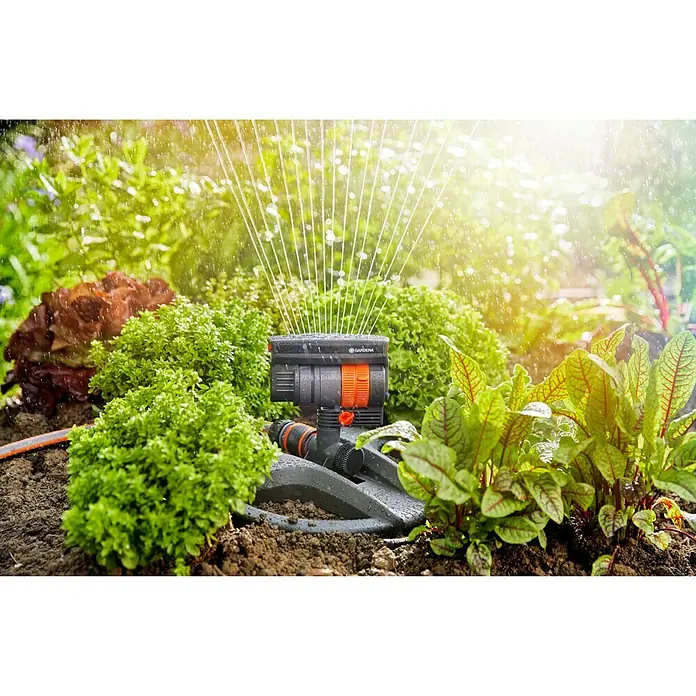 Gardena Viereckregner Aquazoom compact - Max. Regnerfläche: 9 m² - 216 m² - Nahaufnahme eines GARDENA Vielflächenregners im Einsatz, der einen grünen Garten bewässert. Das Bewässerungssystem sorgt für eine effiziente und gleichmäßige Wasserverteilung.