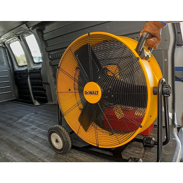 DeWalt Bodenventilator DXF2410 - 190 W, Max. Luftleistung: 148,77 m³/h - Ein gelber, industrieller Ventilator von DeWalt steht in einem Lieferwagen und wird von einer Hand bewegt.