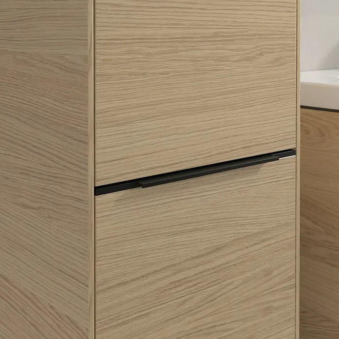 Villeroy & Boch Subway 3.0 Hochschrank - B x T x H: 40 x 36,2 x 171 cm, 2x Tür, Nordik oak, Farbe Griff: Volcano black, DIN Anschlag: Links - Detailaufnahme eines Holzschranks mit schwarzem Griff. Das schlichte Design des Schranks fügt sich nahtlos in moderne Badezimmer ein.