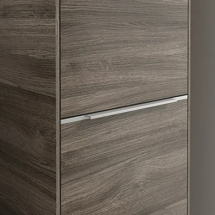 Villeroy & Boch Subway 3.0 Hochschrank - B x T x H: 40 x 36,2 x 171 cm, 2x Tür, Stone Oak, Farbe Griff: Aluminium glänzend, DIN Anschlag: Rechts - Nahaufnahme eines modernen Holzschranks mit einem schlanken, silbernen Griff. Das Möbelstück zeichnet sich durch eine natürliche Holzmaserung aus.