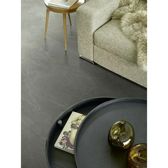 Beauflor PVC-Boden Meterware Feelings - 400 cm, Rockingham, Anthrazit - Elegante Wohnraumaufnahme mit modernem Sofa, stilvollem Beistelltisch und einem runden Couchtisch mit dekorativen Elementen auf edlem Boden.