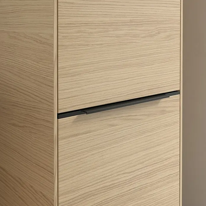 Villeroy & Boch Subway 3.0 Hochschrank - B x T x H: 40 x 36,2 x 171 cm, 2x Tür, Nordik oak, Farbe Griff: Volcano black, DIN Anschlag: Rechts - Nahaufnahme eines Holzschranks mit Schubladen und einem eleganten schwarzen Griff. Die Holzmaserung ist deutlich sichtbar.