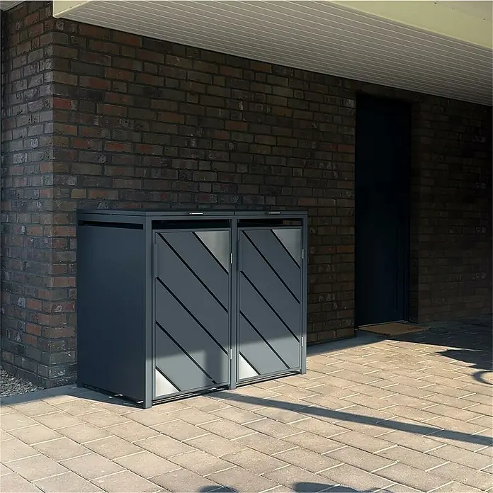 Metzler Mülltonnenbox - 132 x 80 cm, Stahl, Anthrazit, Geeignet für Anzahl Mülltonnen: 2 Stk. - Moderne Mülltonnenbox in Anthrazit mit diagonalen Akzenten vor einer Backsteinmauer.