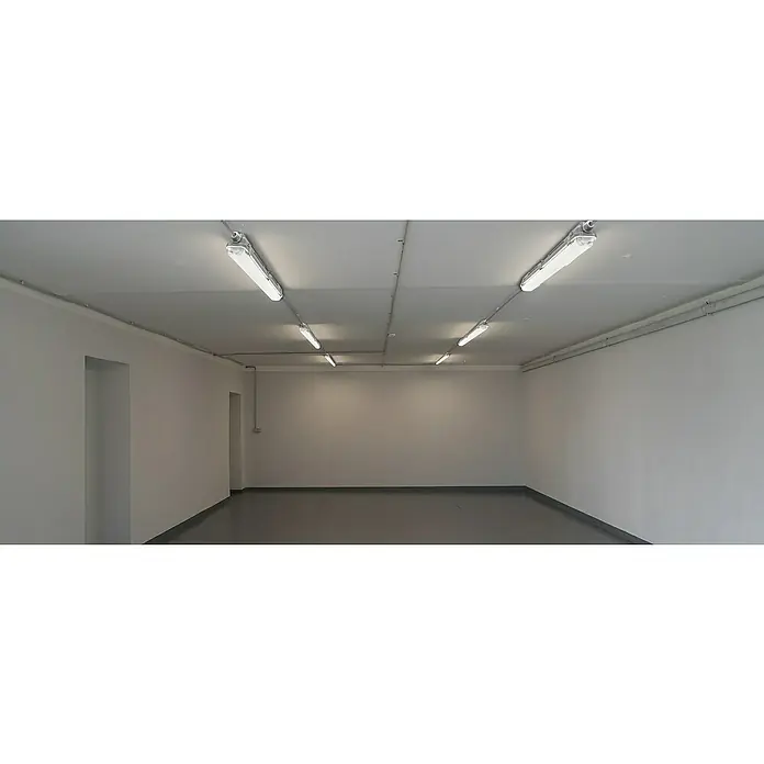 Profi Depot LED-Feuchtraumlichtleiste mit Durchverdrahtung - L x B x H: 128,4 x 6,2 x 6 cm, Lichtfarbe: Tageslichtweiß, 14 W, IP65 - Helles, leeres Lager mit mehreren länglichen Deckenleuchten, die für viel Licht sorgen, und grauem Industrieboden.