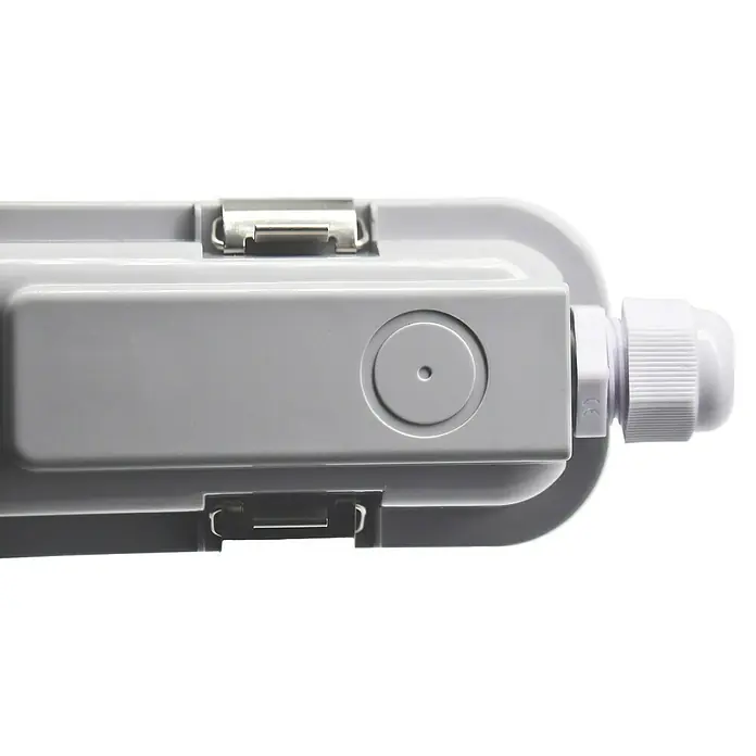 Voltolux Feuchtraumleuchte - L x B x H: 128,4 x 6,2 x 6 cm, Lichtfarbe: Tageslichtweiß, 14 W, IP65 - Nahaufnahme einer grauen Anschlussdose mit Kabelverschraubung, die eine sichere elektrische Verbindung gewährleistet.