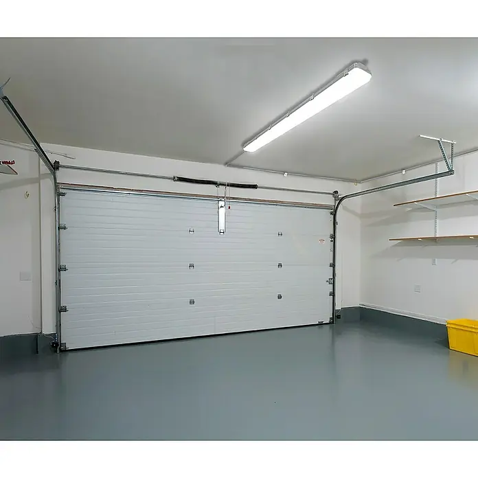 Voltolux Feuchtraumleuchte - L x B x H: 128,4 x 6,2 x 6 cm, Lichtfarbe: Tageslichtweiß, 14 W, IP65 - Innenansicht einer Garage mit weißem Garagentor, grauen Epoxidböden und einer Leuchtstofflampe an der Decke.