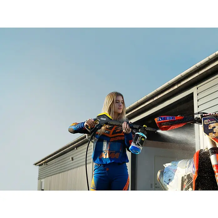 Kärcher Auto-Shampoo - 1 l - Frau reinigt mit einem Kärcher Hochdruckreiniger ein schmutziges Motocross-Motorrad, ideal für die Pflege von Motorsportgeräten.