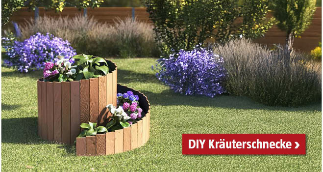 Selbstgemachte Kräuterschnecke aus Holz im Garten, bepflanzt mit Blumen