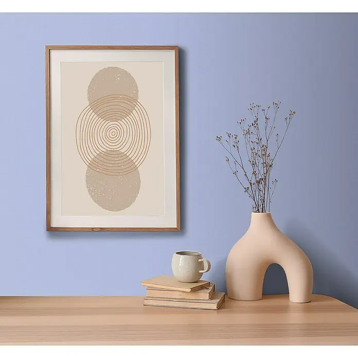 A.S. Création Aquarell Dreams Vliestapete - Blau, Uni, 10,05 x 0,53 m - Elegantes Wandbild mit abstrakten Formen in einem Holzrahmen, ergänzt durch eine stilvolle Vase und Bücher auf einem hellen Tisch.