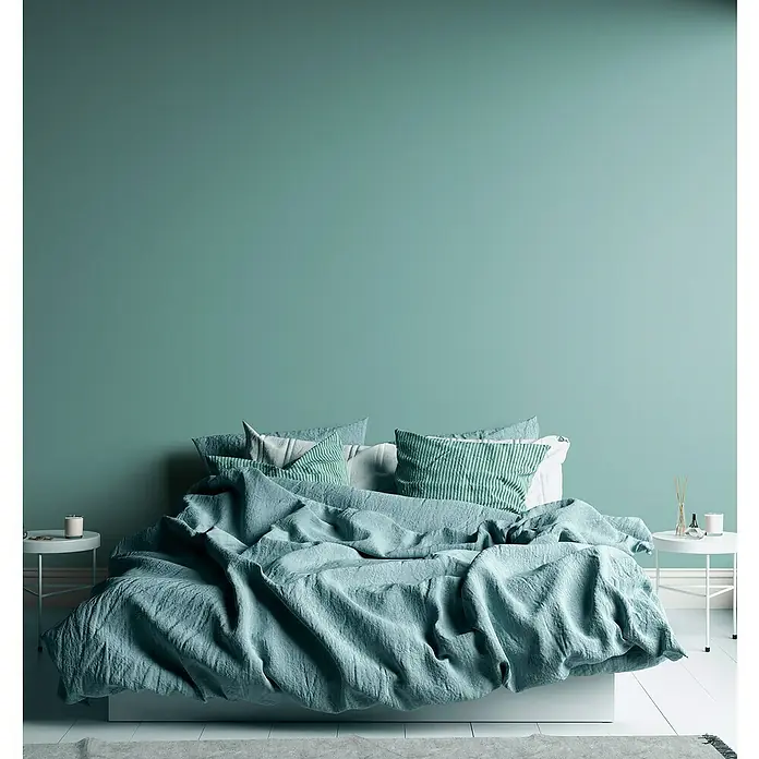 A.S. Création Aquarell Dreams Vliestapete - Türkis, Uni, 10,05 x 0,53 m - Elegantes Schlafzimmer-Interieur mit einem großen, bequemen Bett und einer grünen Wand. Helle Kissen und eine Tagesdecke ergänzen das harmonische Design.