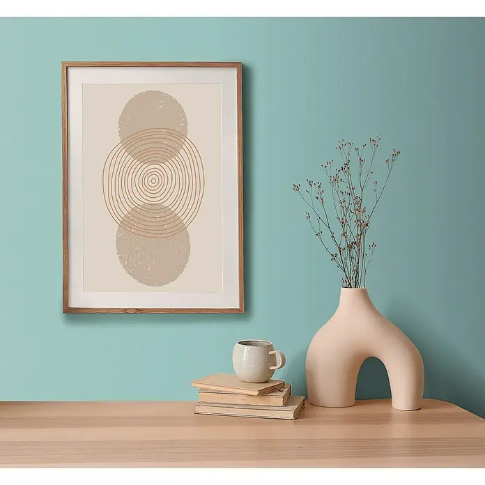 A.S. Création Aquarell Dreams Vliestapete - Türkis, Uni, 10,05 x 0,53 m - Ein gerahmtes abstraktes Wandbild mit konzentrischen Kreisen und geometrischen Formen, das über einem Tisch mit Dekor steht.