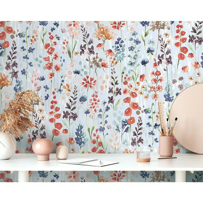 A.S. Création Aquarell Dreams Vliestapete - Hellblau-Bunt, Floral, 10,05 x 0,53 m - Dekorative Tischszene mit floraler Tapete im Hintergrund, die eine Vase, Stiftehalter, einen Spiegel und andere Schreibtischutensilien zeigt.