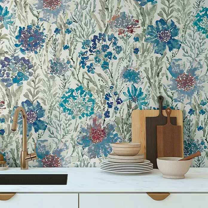 A.S. Création Aquarell Dreams Vliestapete - Blau-Weiß, Floral, 10,05 x 0,53 m - Eine Küchenszene mit floraler Tapete, Holztellern, Schüsseln und einem goldenen Wasserhahn, die eine warme und einladende Atmosphäre schafft.
