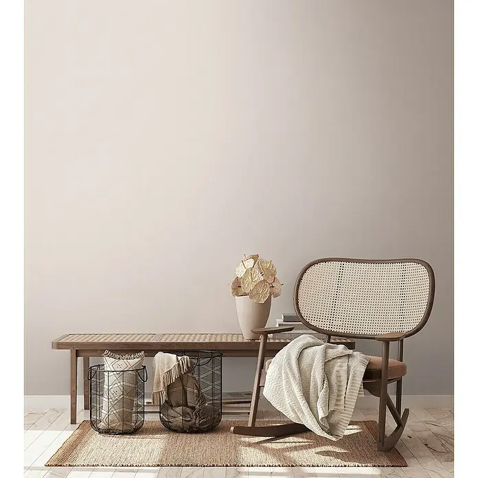 A.S. Création Aquarell Dreams Vliestapete - Creme-Beige, Uni, 10,05 x 0,53 m - Ein gemütlicher Innenraum mit einem Rattansessel, Körben und einem Beistelltisch, der eine warme und einladende Atmosphäre schafft.