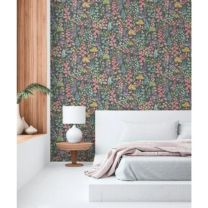 A.S. Création Aquarell Dreams Vliestapete - Schwarz-Bunt, Floral, 10,05 x 0,53 m - Schlafzimmer mit dunkler Blumentapete und weißem Bett. Die Tapete zeigt ein buntes Blumenmuster.