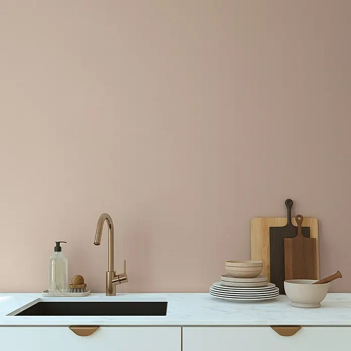 A.S. Création Aquarell Dreams Vliestapete - Beige, Uni, 10,05 x 0,53 m - Küchenspüle mit goldener Armatur, Geschirr und Holzbrett vor rosa Wand.