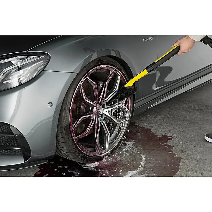 Kärcher Felgenreiniger Premium RM 667 - 500 ml - Felgenreinigung mit einer Bürste: Die gelb-schwarze Bürste säubert effektiv die silberne Felge eines grauen Autos.