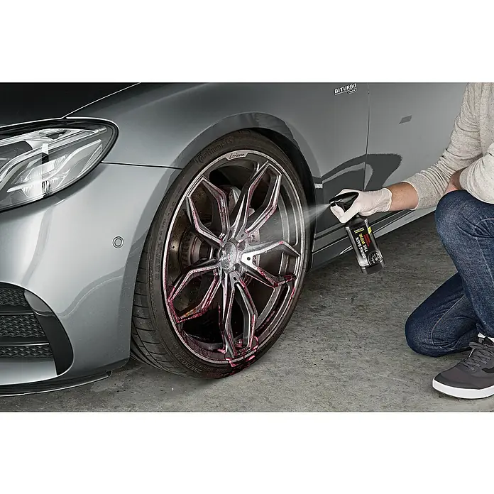 Kärcher Felgenreiniger Premium RM 667 - 500 ml - Eine Person sprüht Kärcher Felgenreiniger auf eine silberne Felge eines Autos. Das Produkt verspricht, den Wow-Effekt zurückzubringen.