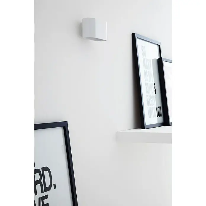 Lucide Wandleuchte Xera - 42 W, L x B x H: 17 x 9 x 9 cm, Weiß, G9 - Wandleuchte mit rechteckiger Form und zwei gerahmten Kunstwerken an einer weißen Wand, die ein modernes und minimalistisches Design zeigt.