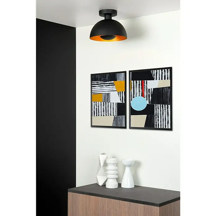Lucide Siemon Deckenleuchte rund - 40 W, Ø x H: 25 x 18,5 cm, Schwarz/ Gold, E27 - Nahaufnahme einer schwarzen Deckenleuchte mit goldenem Inneren, die über zwei gerahmten, abstrakten Kunstwerken an einer Wand hängt.