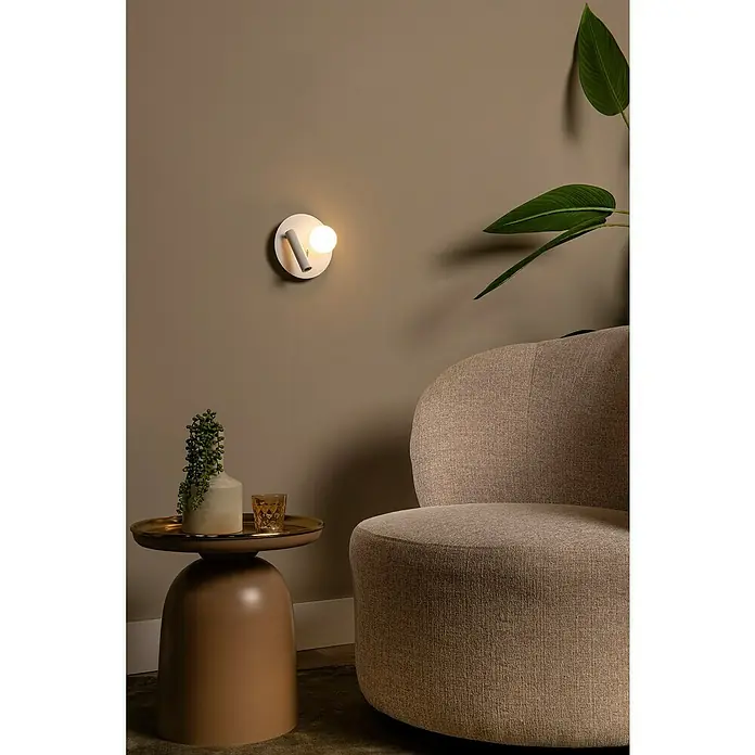 Lucide LED-Wandleuchte rund Matiz - 3,5 W, Ø x H: 16,5 x 19 cm, Weiß, Neutralweiß - Elegante Wandleuchte mit sanftem Licht neben einem stilvollen Beistelltisch und einem gemütlichen Sessel, die eine warme Atmosphäre schaffen.