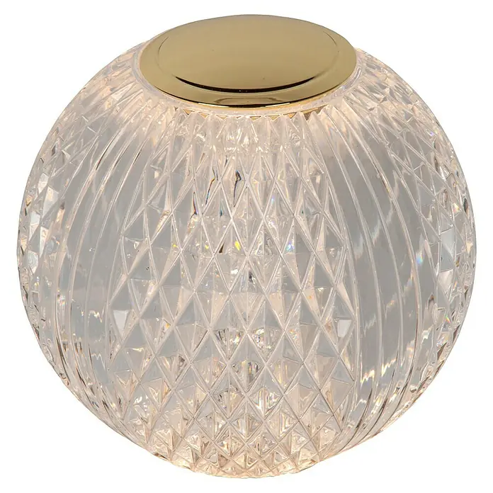 Lucide Cintra Tischleuchte rund - 1,5 W, Ø x H: 9 x 10 cm, Kristall - Diese Nahaufnahme zeigt eine elegante runde Kristalllampe mit goldenem Sockel, die ein warmes Licht ausstrahlt und ihr kunstvolles Design betont.