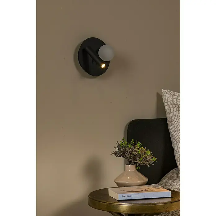 Lucide LED-Wandleuchte rund Matiz - 3,5 W, Ø x H: 16,5 x 19 cm, Schwarz, Neutralweiß - Nahaufnahme einer stilvollen Wandlampe in einem modernen Schlafzimmer, die eine gemütliche Atmosphäre schafft.