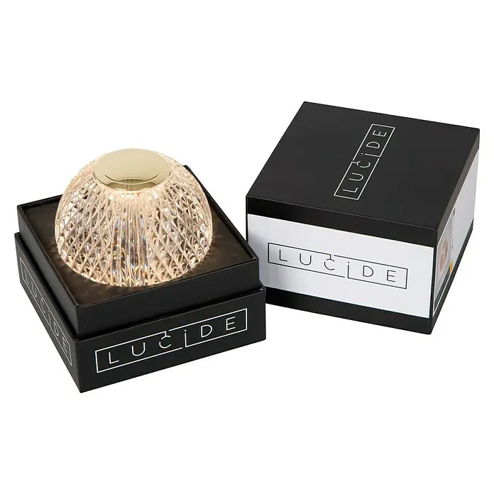Lucide Cintra Tischleuchte rund - 1,5 W, Ø x H: 9 x 10 cm, Kristall - Nahaufnahme einer Lucide Tischleuchte mit Kristall-Design und goldfarbener Oberseite, präsentiert in ihrer schwarzen Verpackung.