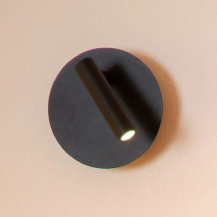 Lucide Akku-Wandleuchte Jolijn - 12 x 12 x 9 cm, Schwarz, Neutralweiß, 2 W, IP20 - Schwarze Wandleuchte mit zylindrischem Spot und warmem Lichtschein, montiert an einer hellen Wand. Moderne Beleuchtung für stilvolle Akzente.