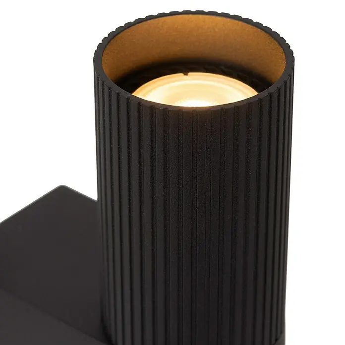 Lucide Clubs Wandleuchte - 50 W, L x B x H: 11,5 x 6,5 x 21,5 cm, Schwarz, Schwarz, GU10 - Nahaufnahme einer modernen, schwarzen Wandleuchte mit geripptem Design und warmem Lichtschein für stilvolle Akzente in jedem Raum.