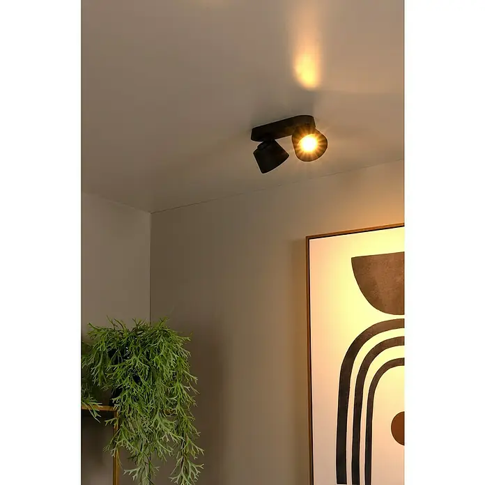 Lucide Deckenstrahler Trigono - 40 W, L x B x H: 26,5 x 11 x 11 cm, Schwarz, GU10, Anzahl Leuchtmittel: 2 Stk. - Nahaufnahme einer schwarzen, deckenmontierten Doppelleuchte, die warmes Licht in einem modern eingerichteten Raum ausstrahlt.