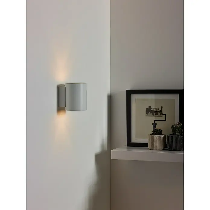 Lucide Wandleuchte Xera - 42 W, L x B x H: 11 x 9 x 11,5 cm, Weiß, G9 - Moderne Wandleuchte aus Metall in Grau, die ein warmes, indirektes Licht nach oben und unten abstrahlt, montiert an einer weißen Wand.